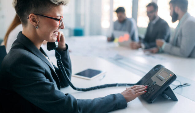 Beautiful Woman On Phone In Busy Modern Office